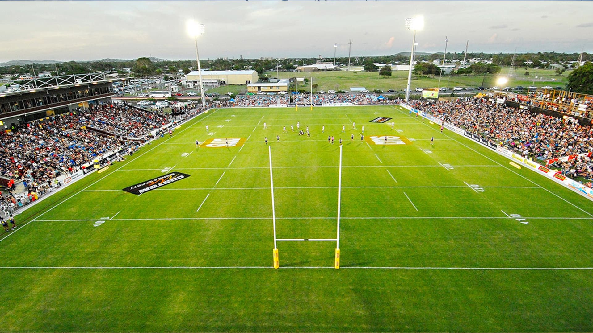 An aerial view of BB Print Stadium with players gathered in the middle of the field.