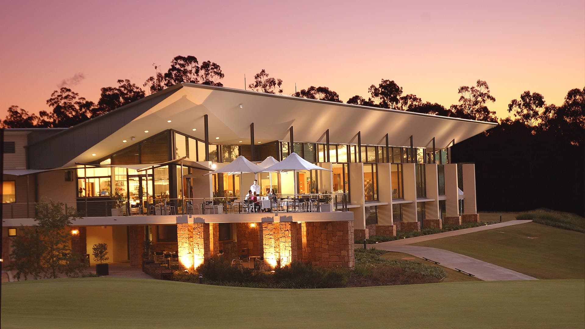 A wide angle view of Brookwater Golf and Country Club building at sunset.