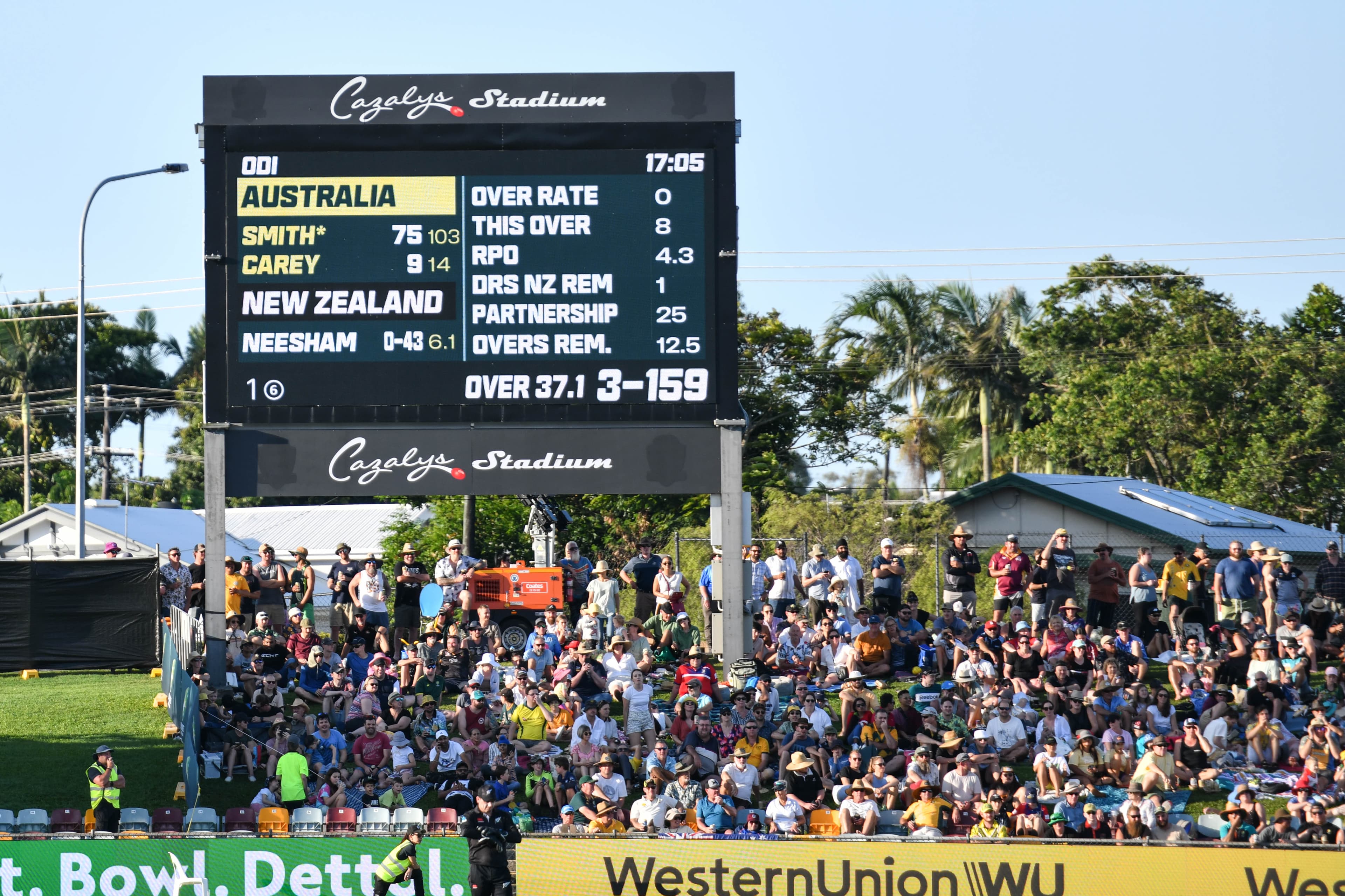 A scoreboard with a large crowd of people around it at Cazalys Stadium in Cairns