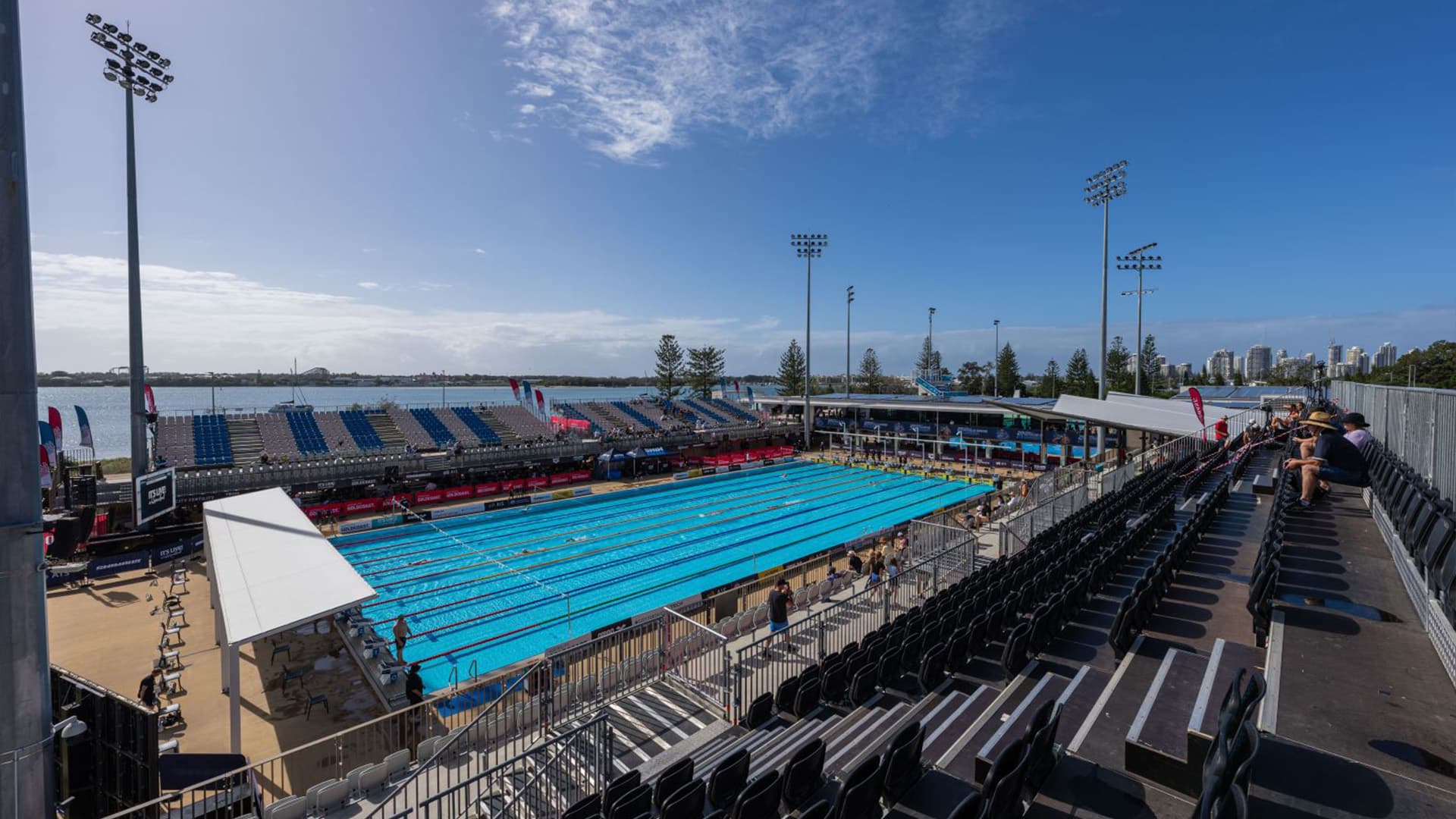 A wide angle view of the swimming pool at the Gold Coast Aquatic Centre with the ocean in the background.