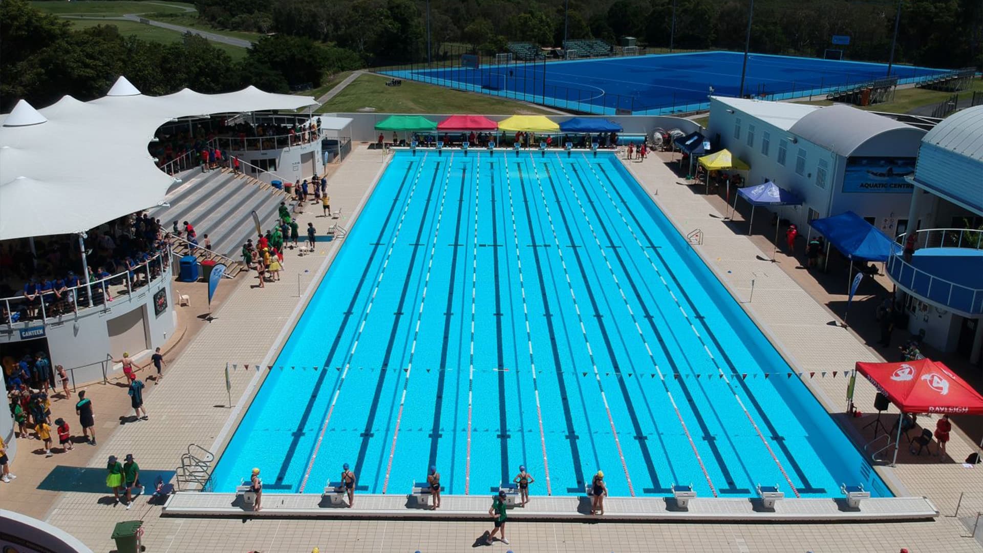 An aerial view of the swimming pool at the Gold Coast Performance Centre with swimmers standing at the starting blocks.