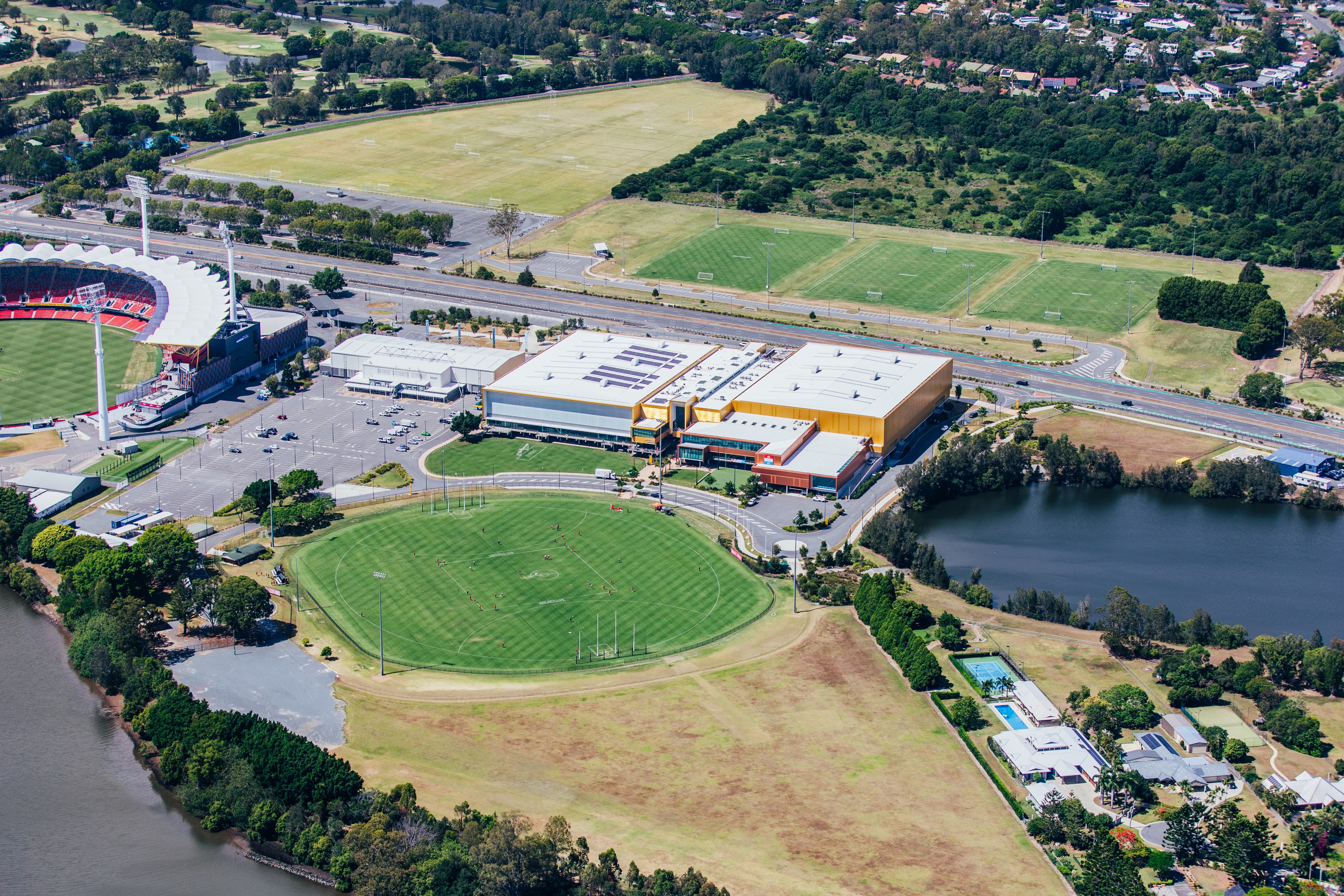 Aerial view of the Gold Coast Sports and Leisure Centre showing surrounding facilities including round oval and lake