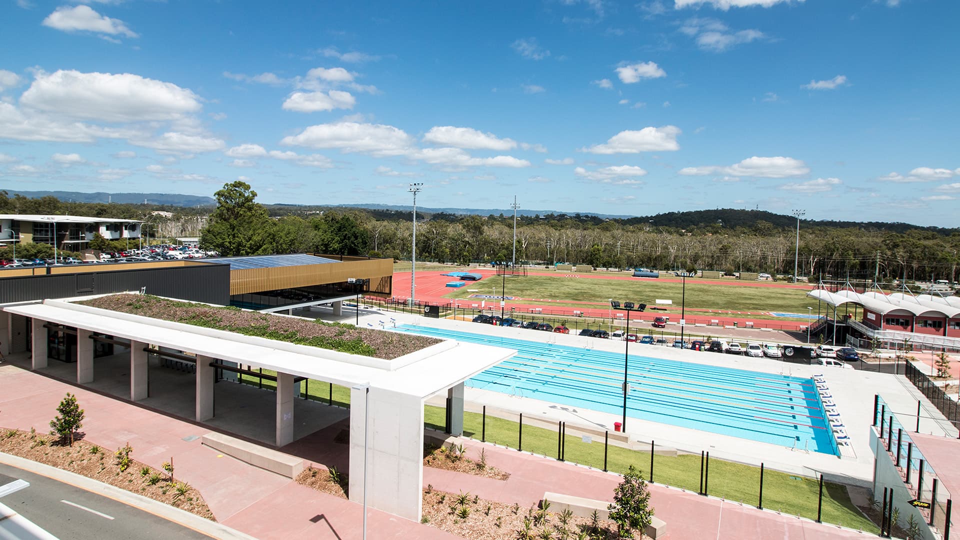 An aerial view of the swimming pool at Griffith University Aquatic Centre and the athletics in the background.