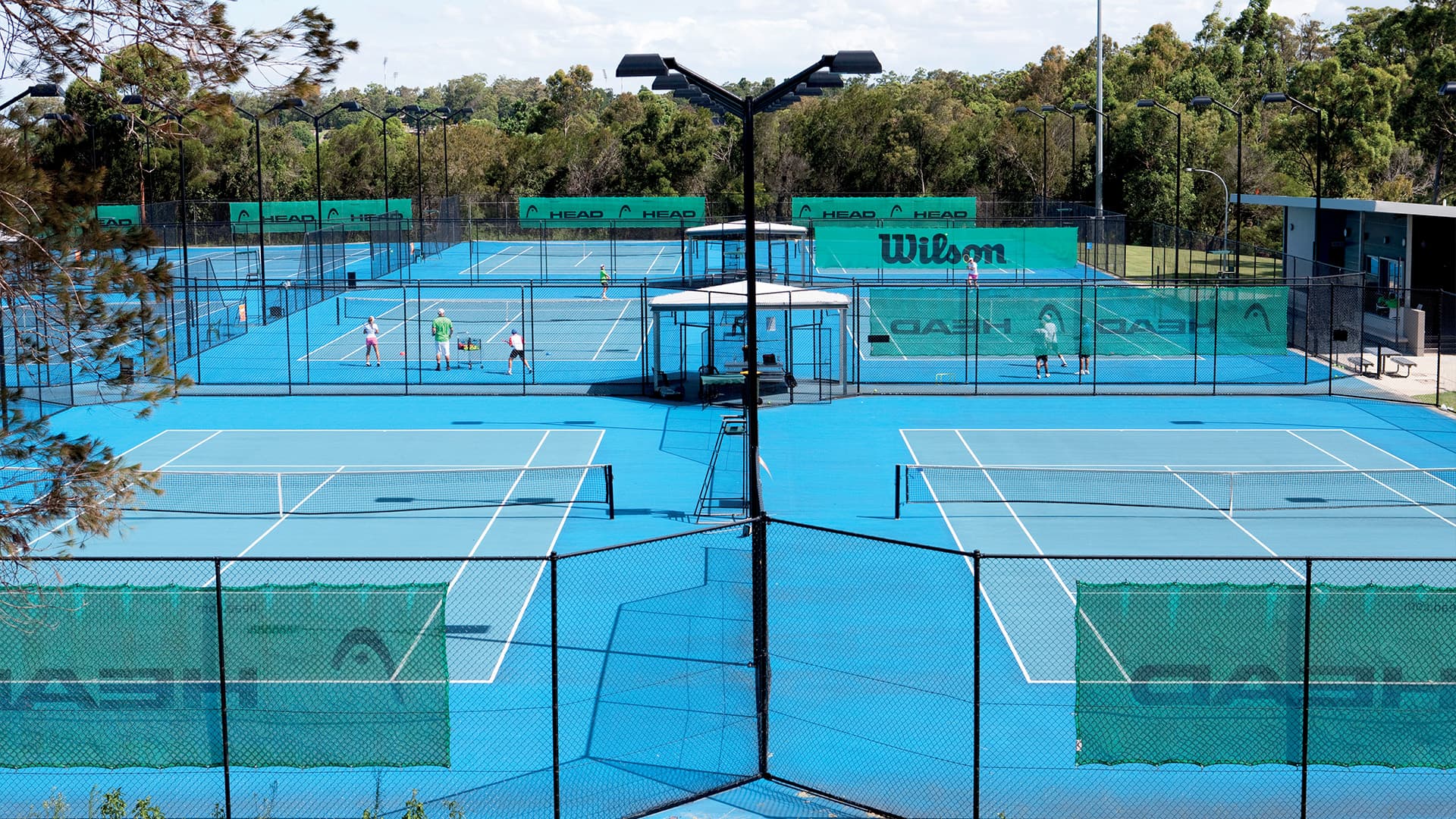 An aerial view of the blue tennis courts at Griffith University Tennis Centre.