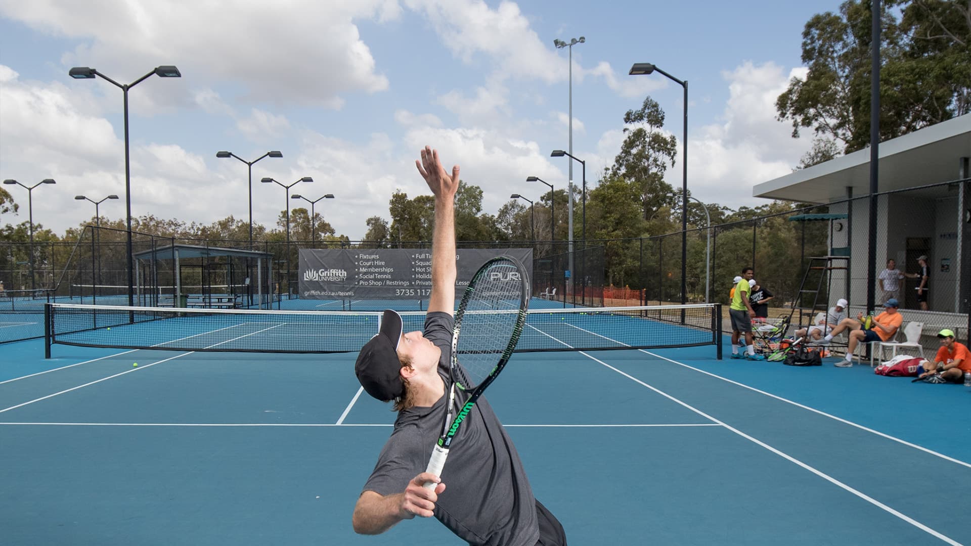 Close view of man about to hit his serve. 