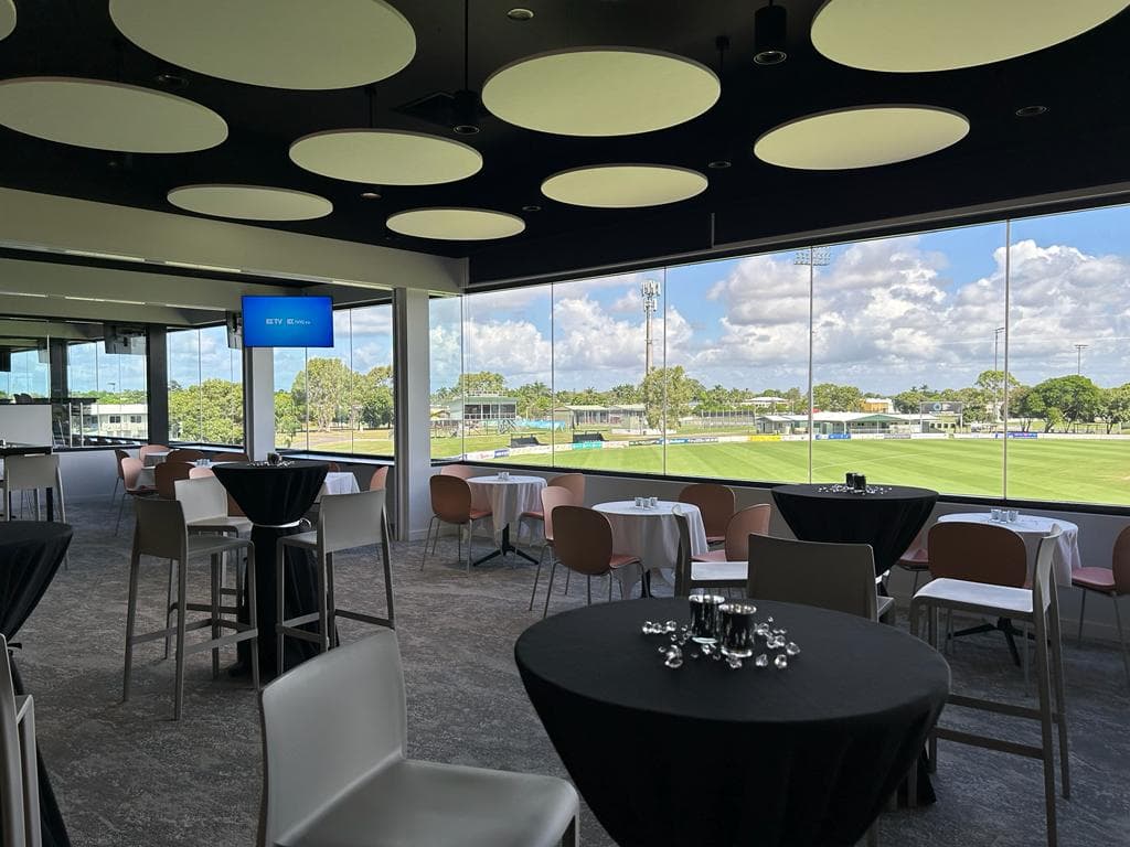 Image of tables and chairs inside the Great Barrier Reef Arena event space overlooking the oval.