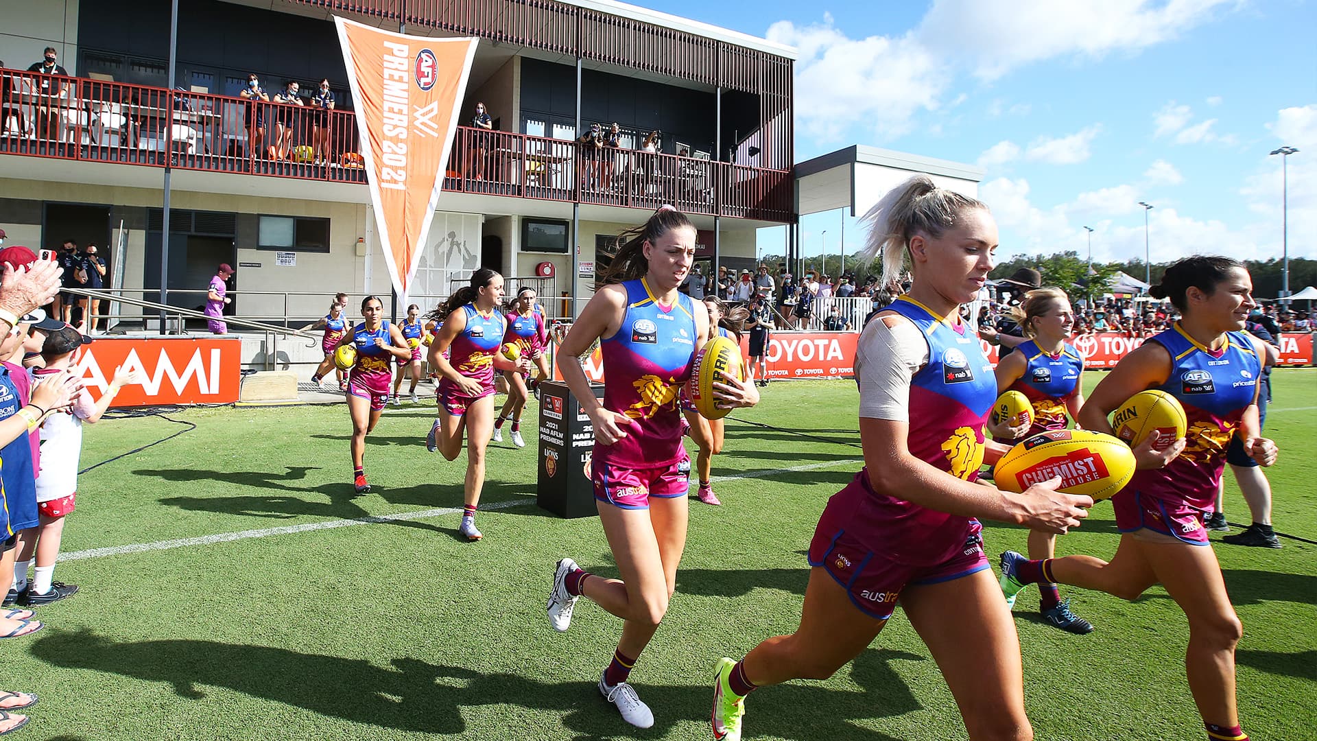 Women's AFL team running into the field at Maroochydore Multi Sport Complex 