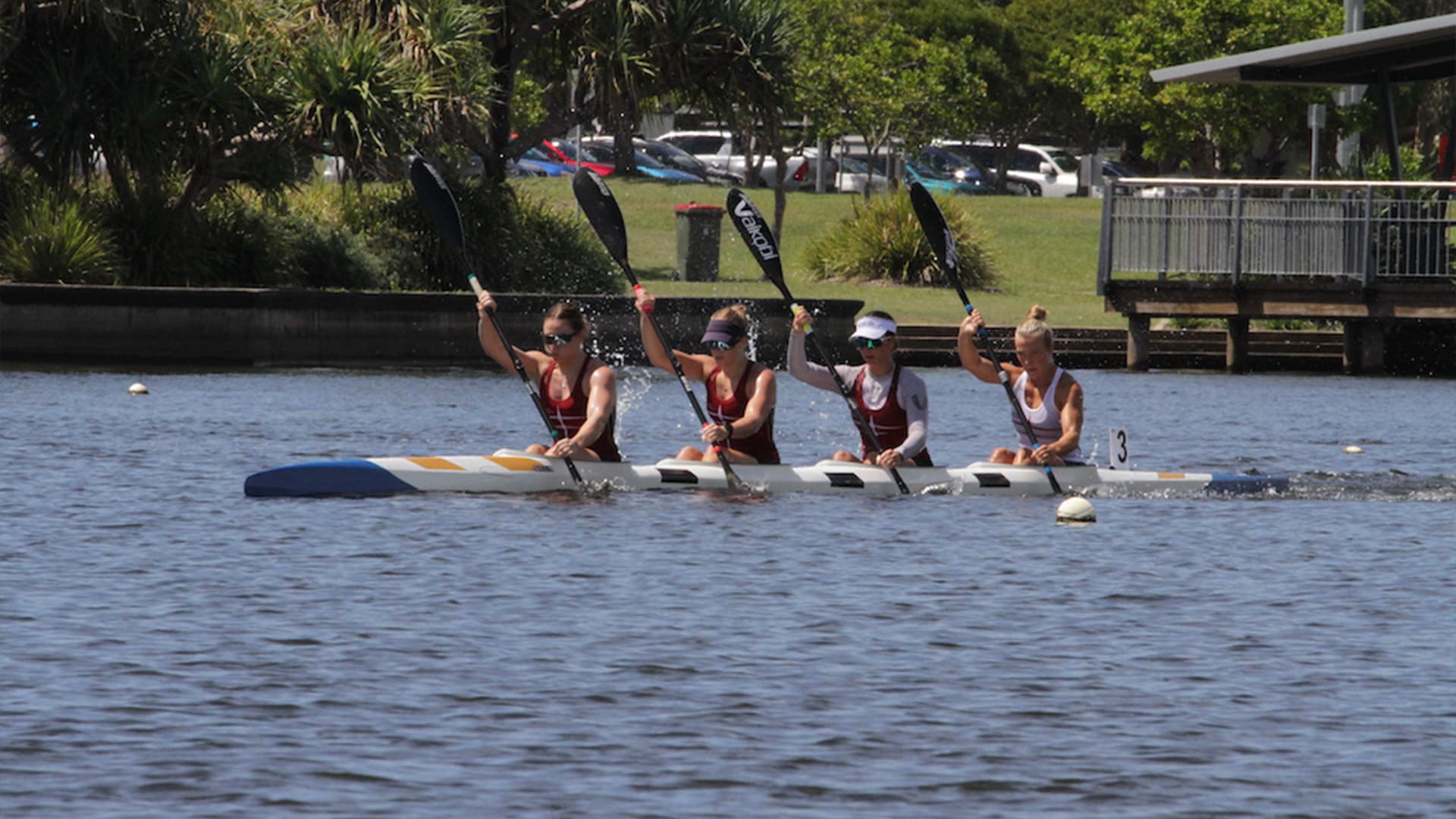 Team of four women in a canoe paddling in synch.