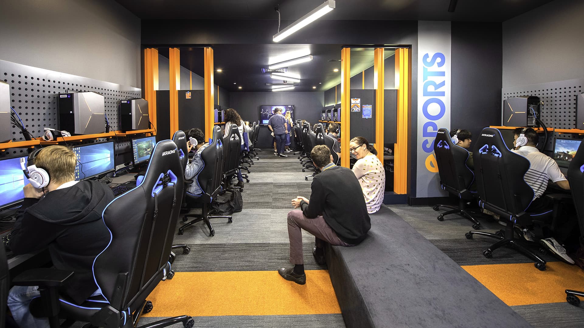 QUT students talking and gaming at the Gardens Point eSports centre.