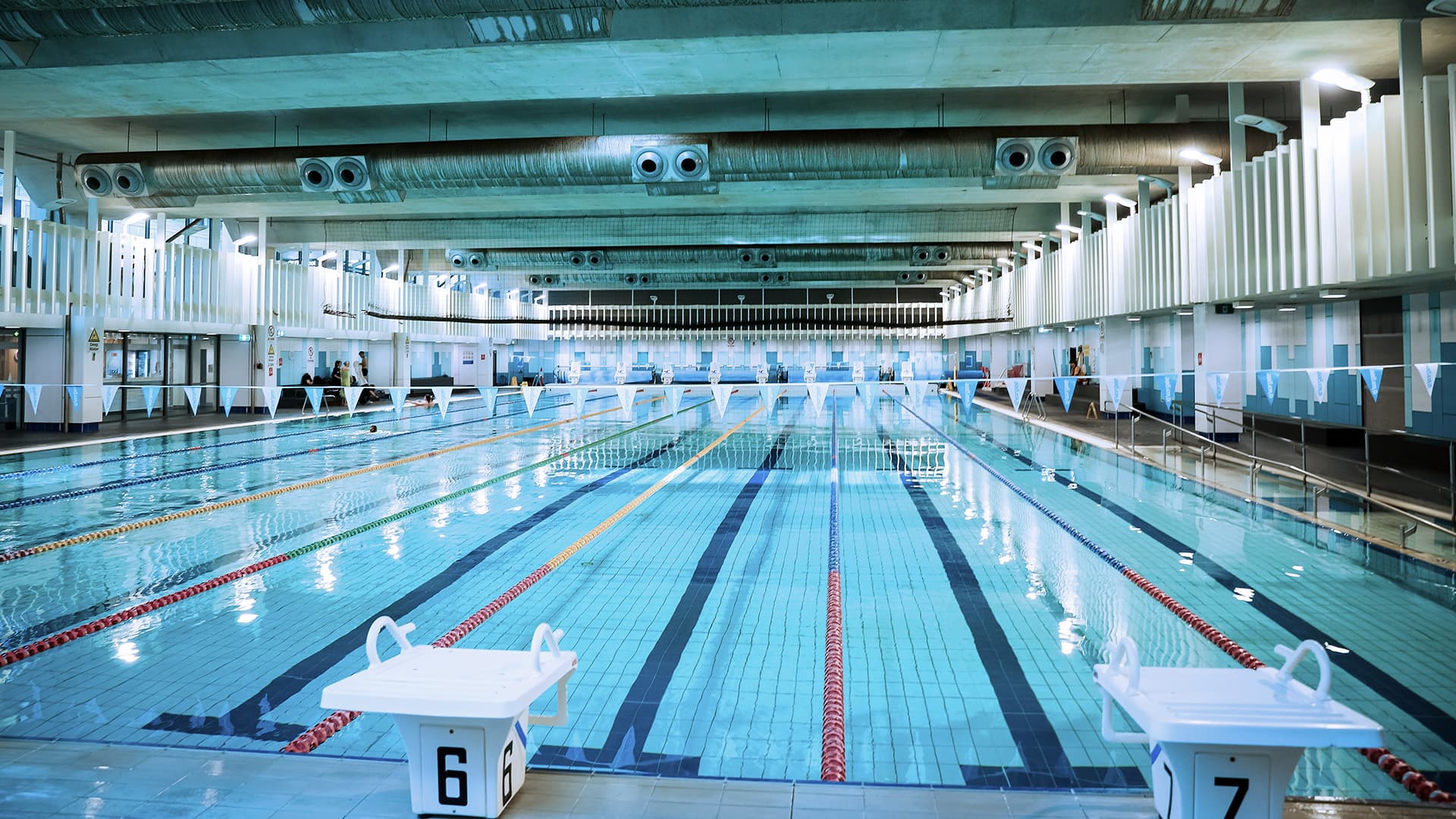 A wide angle view of the indoor swimming pool at Queensland University of Technology Garden's Point campus with one person in the pool.