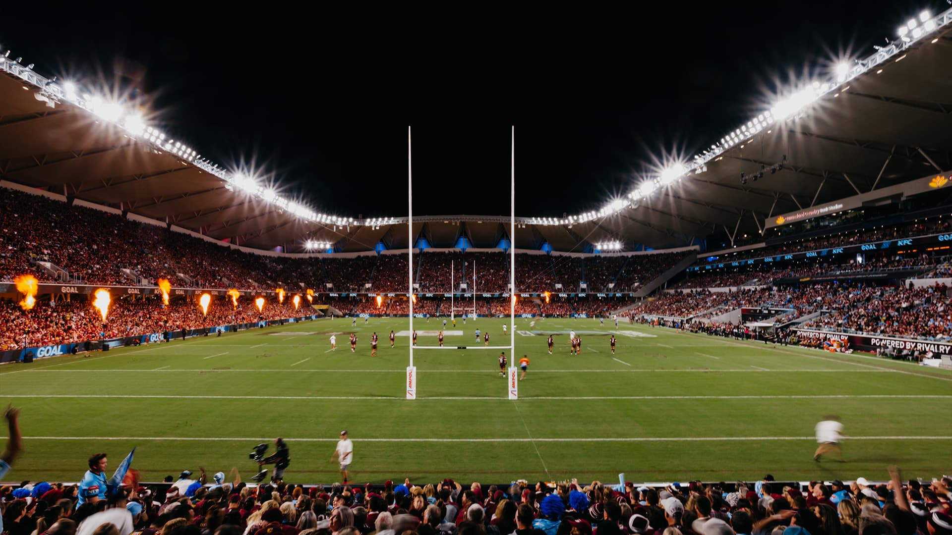 Crowd view of the Queensland Country Bank Stadium from behind the goal during a night game.