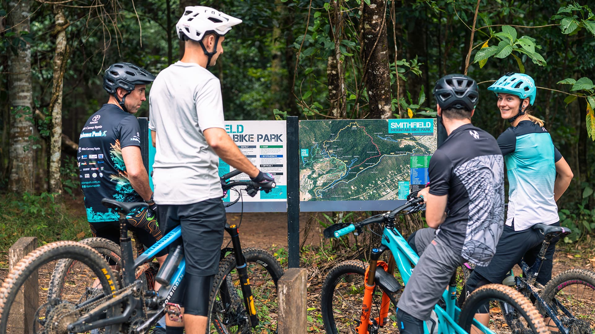 Four mountain bikers looking at a map at Smithfield Mountain Bike Centre.