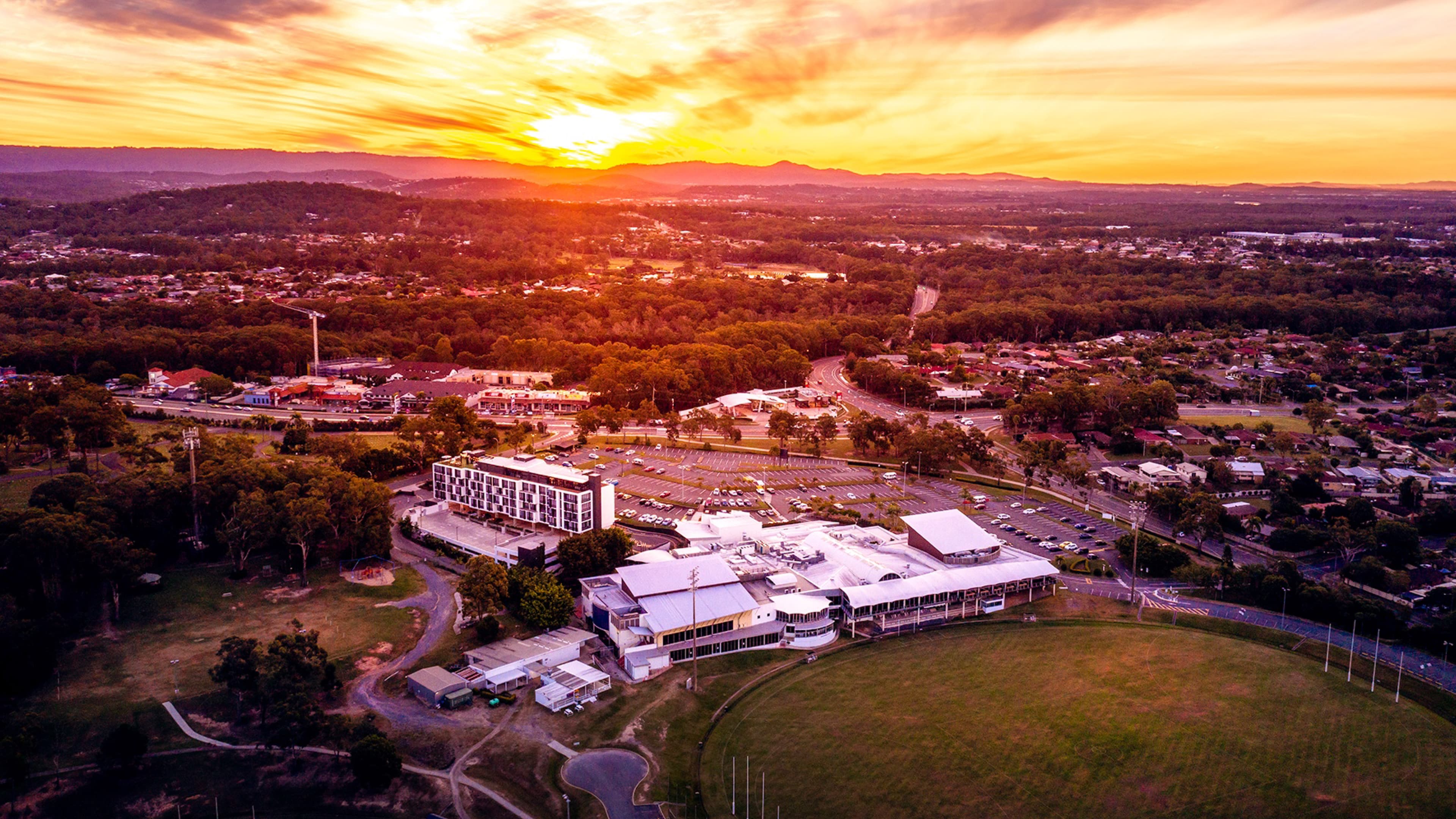 Wide angle shot of the sun setting behind the mountains with the Southport Sharks in the foreground