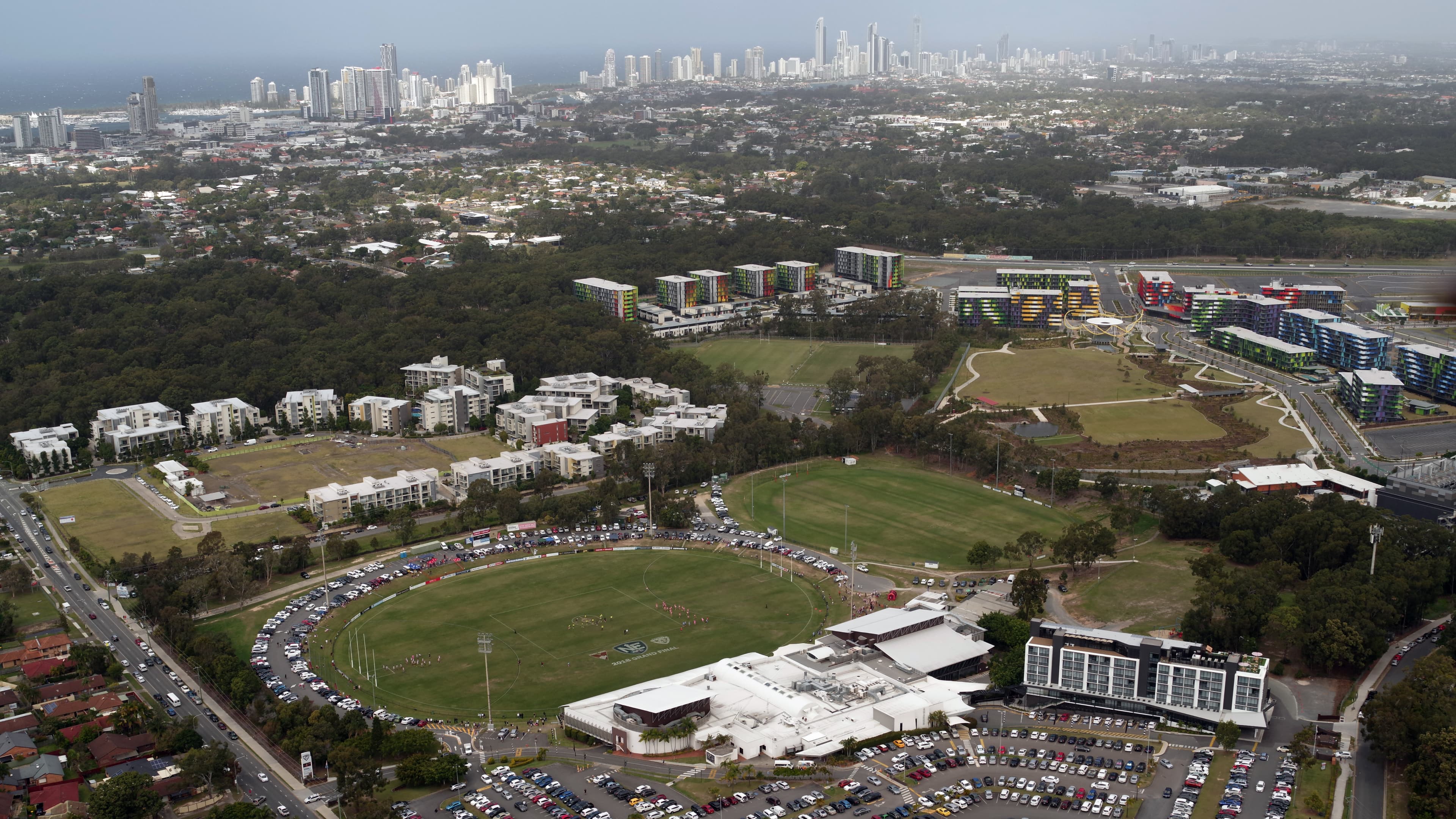 Aerial view of Southport Shark with two oval fields and a large building next to them