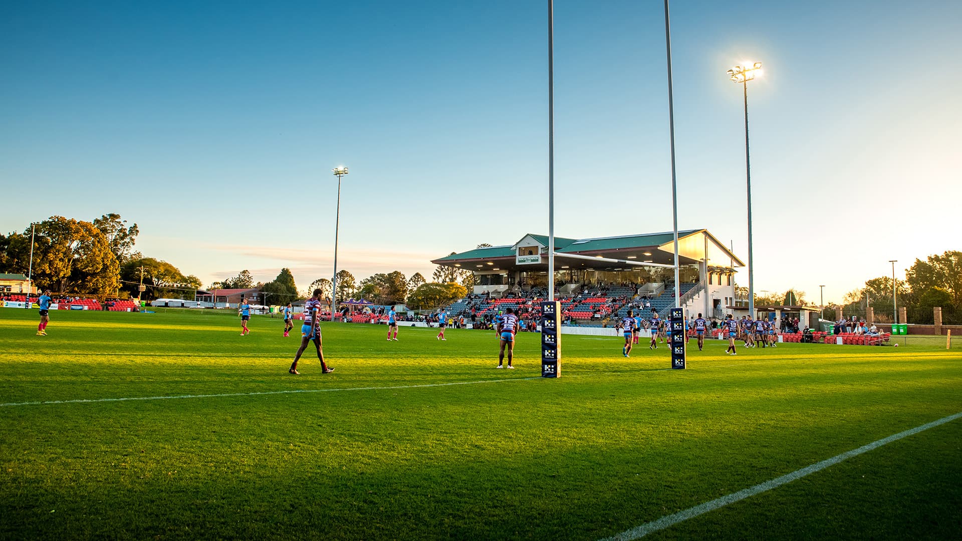 Afternoon view of a team of Rugby players on the field with a small crowd watching at the Toowoomba Sports Ground Field.