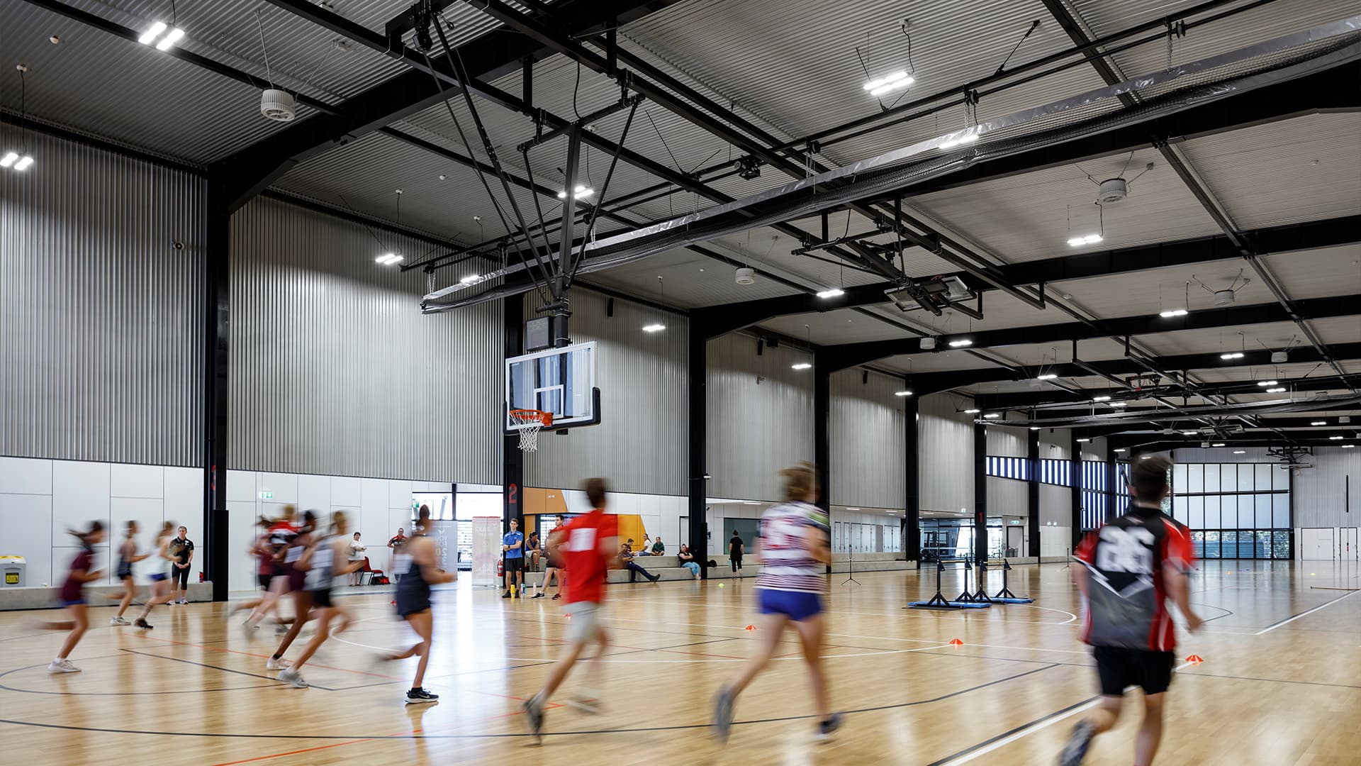 A row of young athletes running drills up and down the indoor basket ball court in the Townsville Sports Precinct.