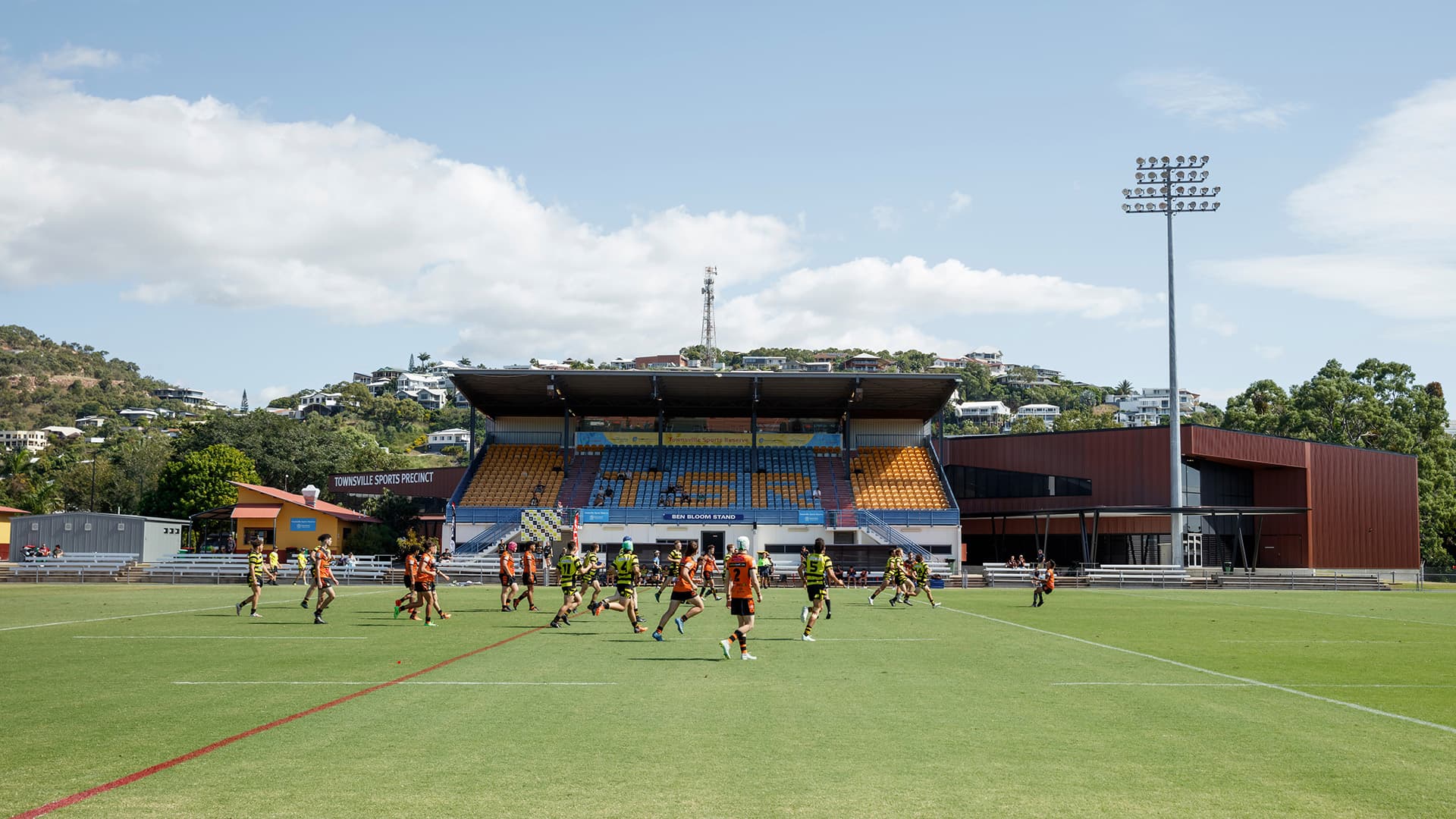 Two teams playing rugby at the Townsville Sports Precinct during the day.