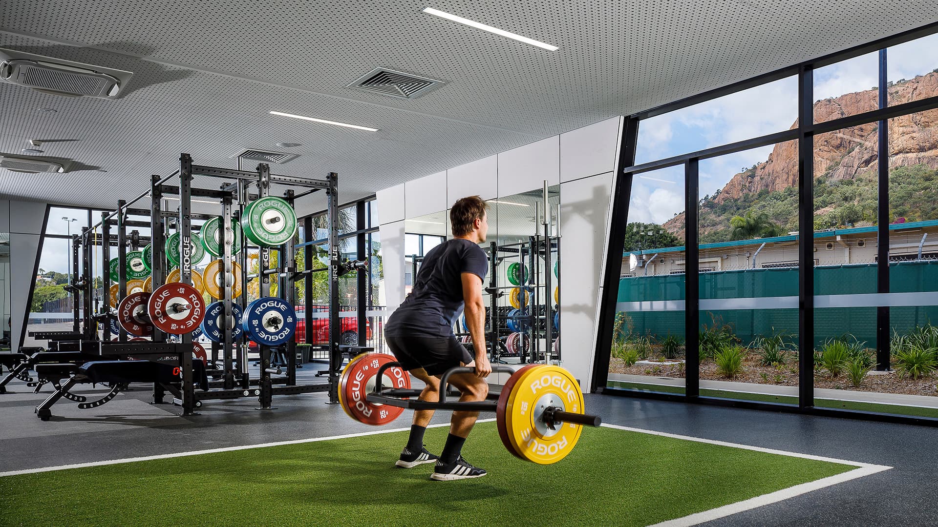 A man lifting weight in the gym at the Townsville Sports Precinct.